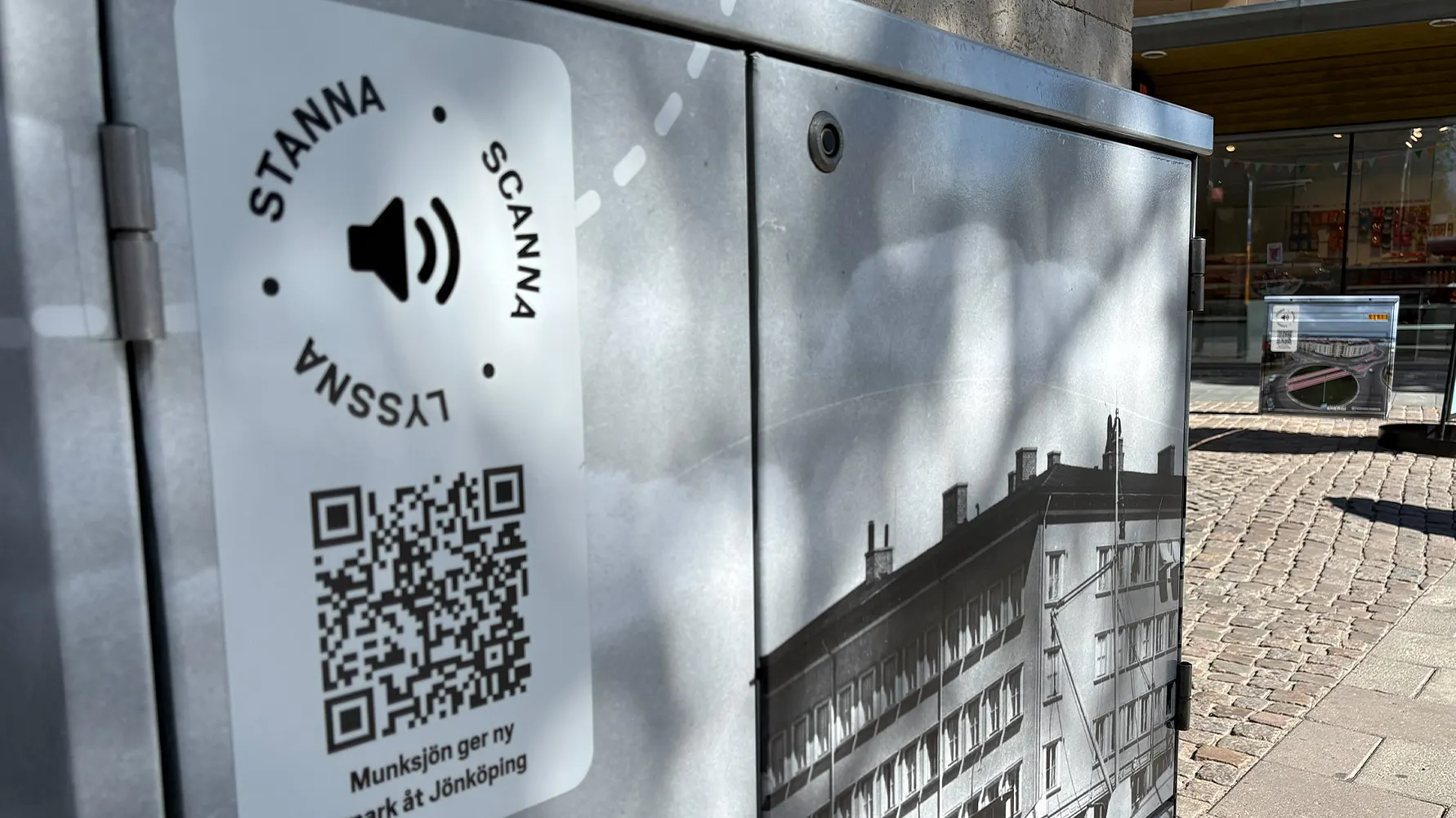 Qr-kod är klistrad på ett elskåp i centrala jönköping, vid skanning kan man lyssna på ett poddavsnitt om Munksjön. 