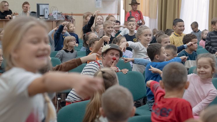 Foto från en tidigare turné till Ukraina 2023. Ukrainska barn leker Kurragömma tillsammans med artisten Jonas Sjögren. 