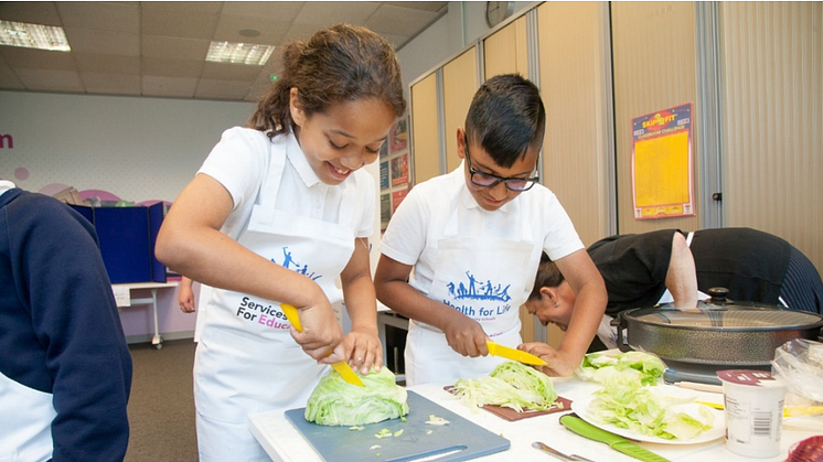 Children chopping vegetables at Health for Life event