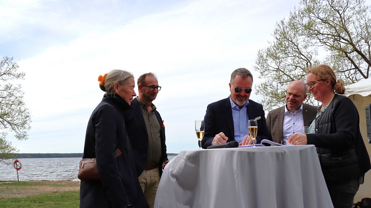 Magnus Weberg, kommunstyrelsens ordförande i Sjöbo kommun, signerar Unesco-ansökan.
