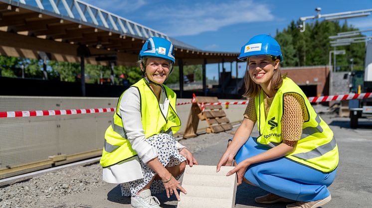 Konsernsjef i Sporveien, Birte Sjule og byråd for miljø og samferdsel, Sirin Stav, legger ned den aller første ledelinjesteinen som skal hjelpe blinde og svaksynte å lettere reise med T-banen fra Mortensrud T-banestasjon. Foto: Sporveien