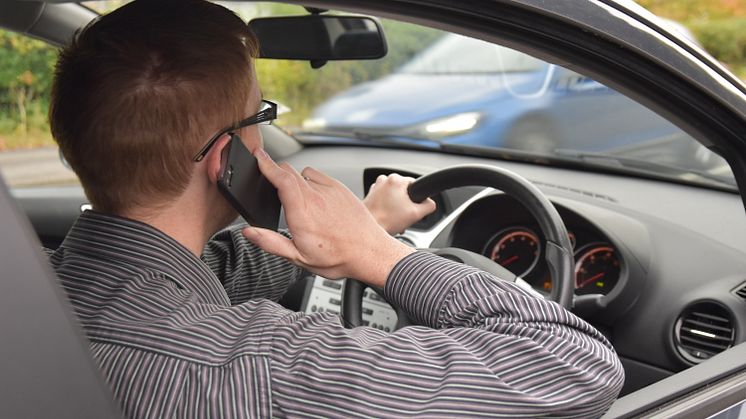 Driver using a mobile phone at the wheel