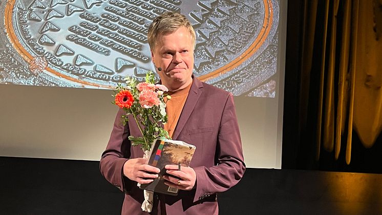 Fredrik Nyberg tar emot utnämningen årets Brunnslockspoet 2024 under Umeå internationella litteraturfestival, Littfest.