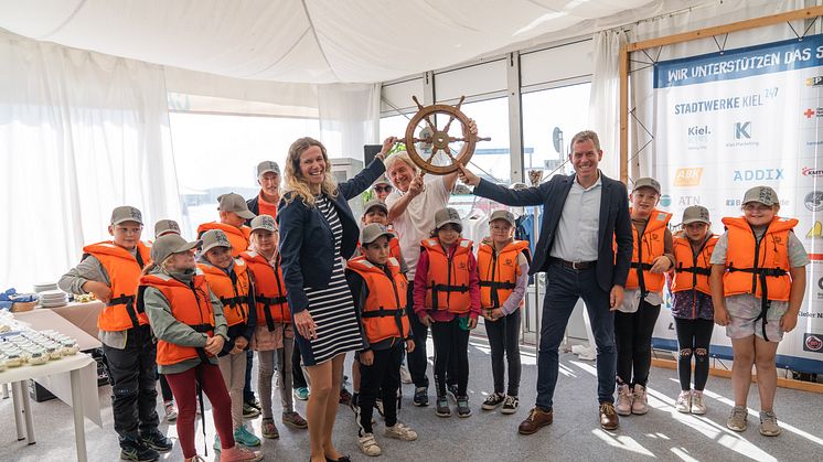 Die Sailingkids der Fritz-Reuter-Schule übergeben das Steuerrad zurück an die Stadtwerke Kiel, Kiel-Marketing und den Oberbürgermeister