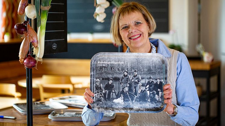 Lill Spenninge, måltidschef på Klippans kommun, visar de nya brickorna med historiska motiv från bygden.