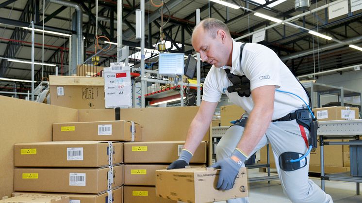 An Audi employee uses the exoskeleton when packing car components in CKD (completely knocked down) logistics at the Ingolstadt plant