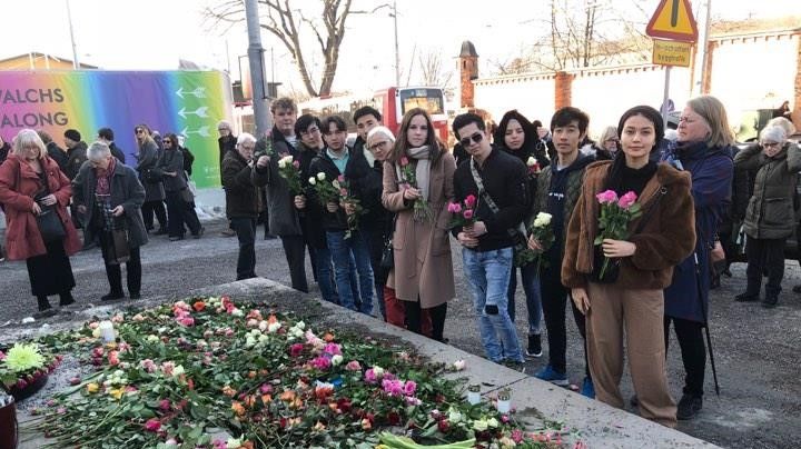 Flyktingvänner och flyktingar lägger ner blommor med tanke på alla dem som Sverige vill utvisa till Afghanistan.