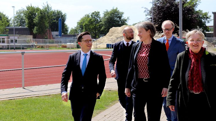 Minister Falko Mohrs (l.) beim gemeinsamen Rundgang über den Campus. Im Hintergrund ist die Baustelle für den neuen Sportcampus der Universität Vechta zu sehen. 