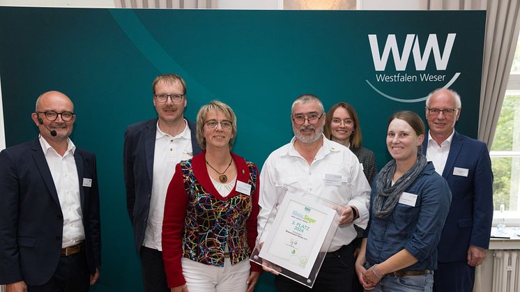 Die Jury-Mitglieder Andreas Speith (l.) und Carolin Wicke (3. v. r.) sowie der stv. Bürgermeister von Höxter Hans-Josef Held gratulieren dem Wassersportverein zum dritten Platz.