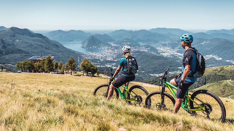 Mountainbiker geniessen das Lugano Panorama bei der Capanna Monte Bar oberhalb Capriasca 