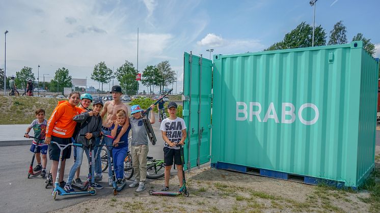 Barn och ungdomar samlade kring BRABOs utlåningscontainer i Vilunda aktivitetspark