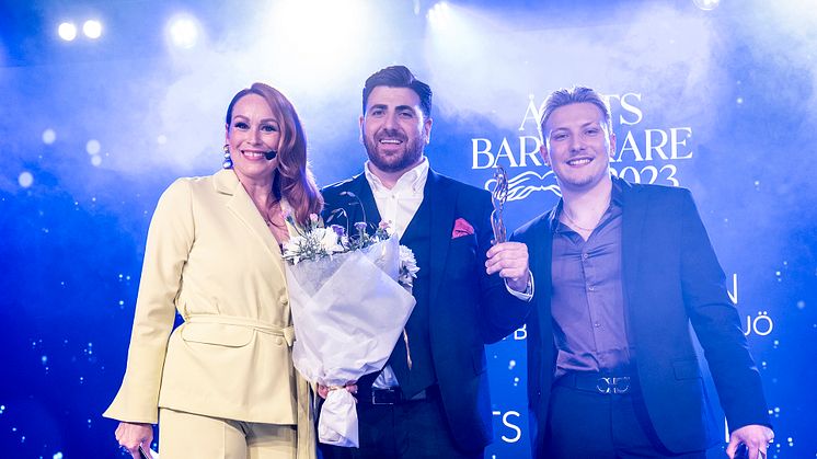 Elias Habibson mottar priset som Årets Barberare 2023 av Wiveka Gillow, Frisörföretagarna och Oliver White, ambassadör för BabylissPro