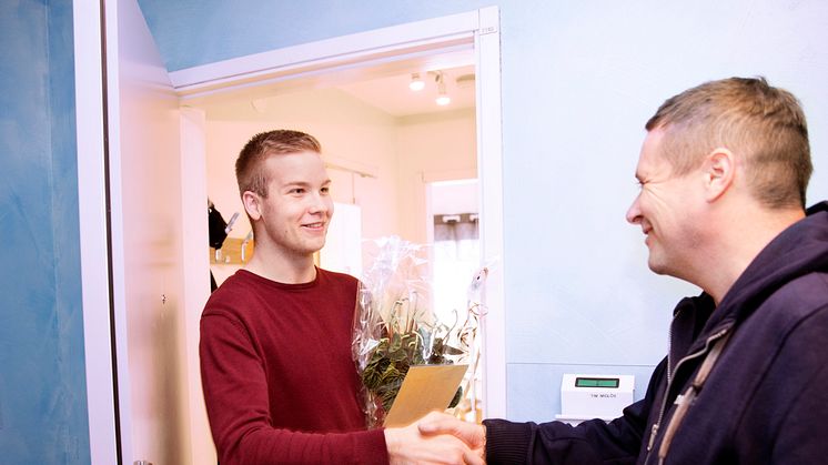 Studenten Tim Midlöv svarade på enkäten Nöjd Studbo och vann utlottningen av en månadshyra. Kvartersvärd Ian Pearson gratulerar.