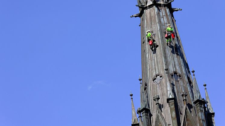 Två klättrare inspekterar tornen på Uppsala Domkyrka