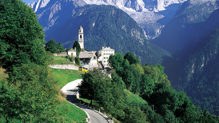 Postauto im Kanton Graubünden: das Dorf Soglio im Bergell, im Hintergrund die Sciora-Bergkette.  © Die Post/Schweiz Tourismus (ST/swiss-image.ch)