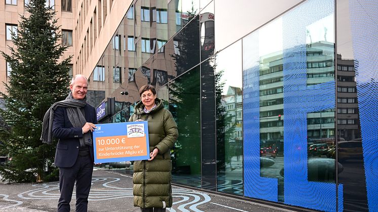 LEW-Vorstand Dietrich Gemmel überreicht Simone Burk-Seitz, 1. Vorsitzende des Vereins Kinderbrücke Allgäu e.V., einen symbolischen Scheck in Höhe von 10.000 Euro. (Foto: LEW / Thorsten Franzisi)