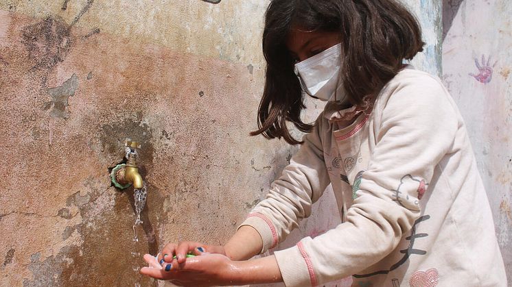 Tala, 9 år och från Syrien, tvättar sina händer för att minska risken för virusspridning.