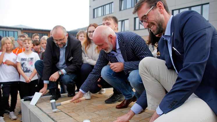 Landrat Daniel Kurth (v.l.), Schulleiter Mafred Reinicke und Bürgermeister Maximilian Wonke verlegen symbolisch die letzten Pflastersteine. Foto: Pressestelle LK Barnim/Oliver Köhler