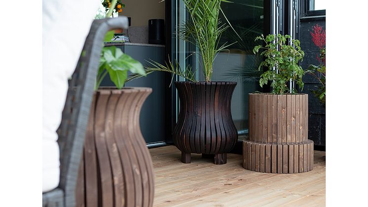 Skapa en härlig miljö på verandan med stora växter i naturliga krukor