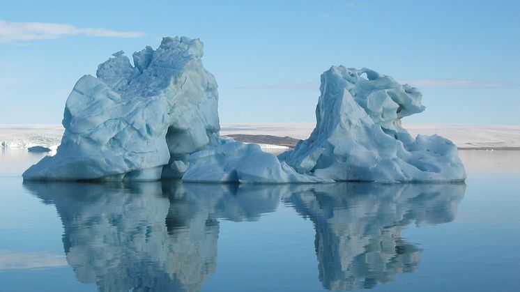 Isfjell som speiler seg i vannflaten