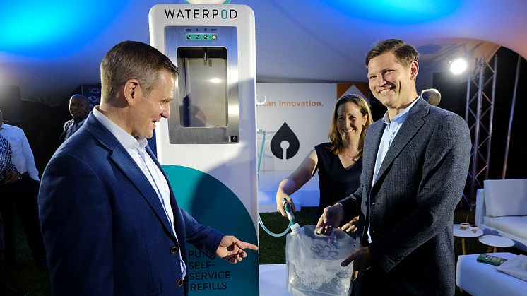 Filling a reuseable water pouch from the Waterpod are Blue CEO Anders Jacobson (right) and James Steere (left), I-Drop Water co-founder and Director Bluewater operations in Africa.