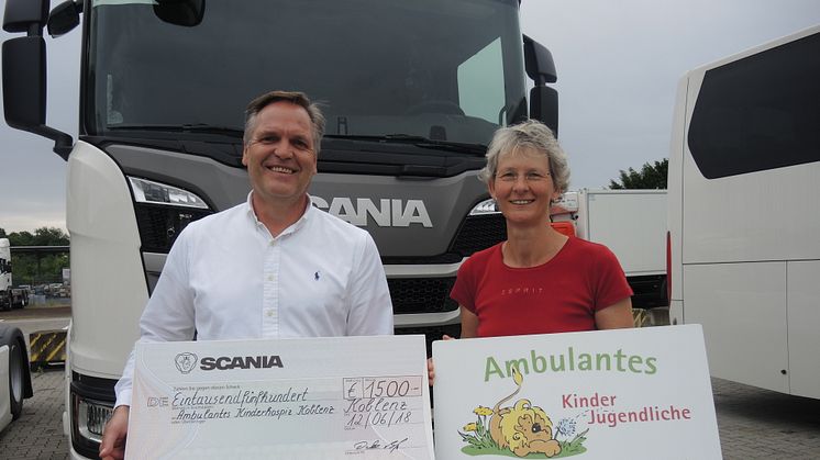 Detlev Both, Mitglied des Betriebsrats von Scania Deutschland, überreicht den Spendenscheck in Höhe von 1.500 Euro an Ute Bohnstengel vom ambulanten Kinder- und Jugendhospiz in Koblenz.