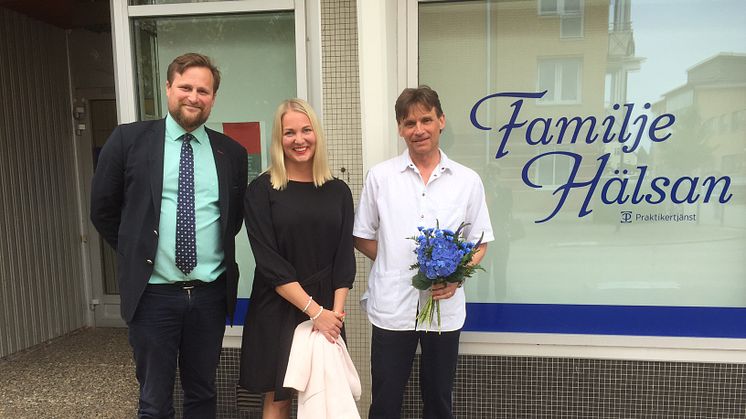 Moderatpolitikerna Carl Johan Sonesson och Ulrika Heindorff överlämnar blommor till verksamhetschefen på Familjehälsan Lars-Göran Winberg.