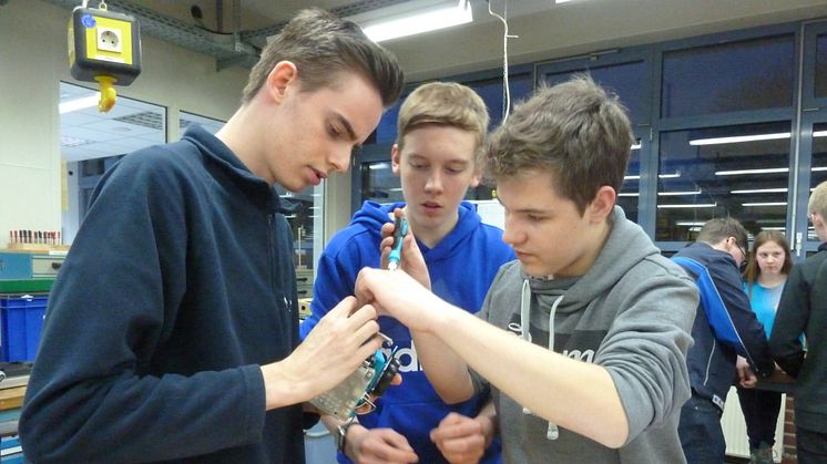 WWE- Azubi Mark Hindersen, Jonas Oehler und  Raphael Kolax von der Gesamtschule Rödinghausen  bauen einen Mini-Roboter in der Ausbildungswerkstatt in Kirchlengern (v. l.).