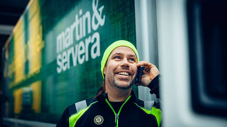 Bilden visar chaufför från Martin & Servera Restauranghandel som pratar i telefon utanför hytten på sin ellastbil. Fotograf: Magnus Fond.