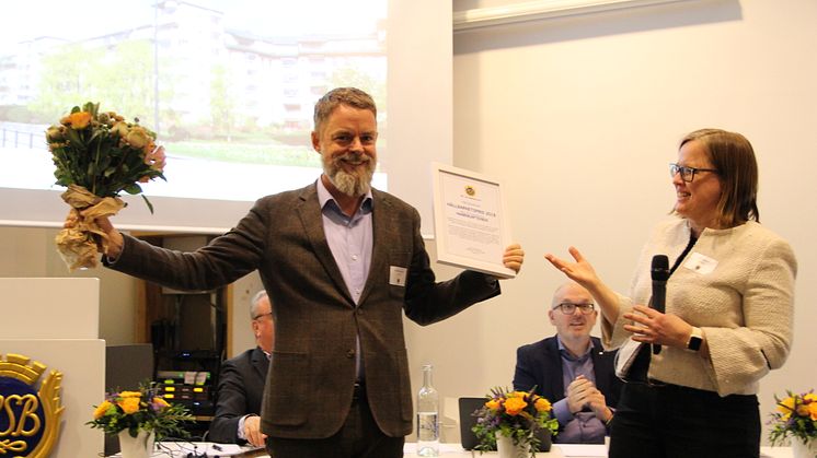 David Samuelsson, ordförande i HSB brf Hamnkaptenen på Södermalm, tar emot 2018 års hållbarhetspris från HSB Stockholms styrelseordförande Jenny Hjalmarsson. 