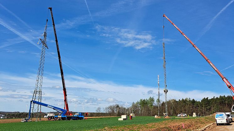 Bevor neue Stromleiterseile über die A3 gespannt werden können, sichert ein Kran den defekten Mast (links) und ein Kran ist beim Bau des Provisoriums im Einsatz.