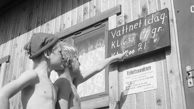 Röda Korsets stuga vid Lill-Olas. Två pojkar kollar vattentemperaturen.© Sandgren-Petersson, 1952.