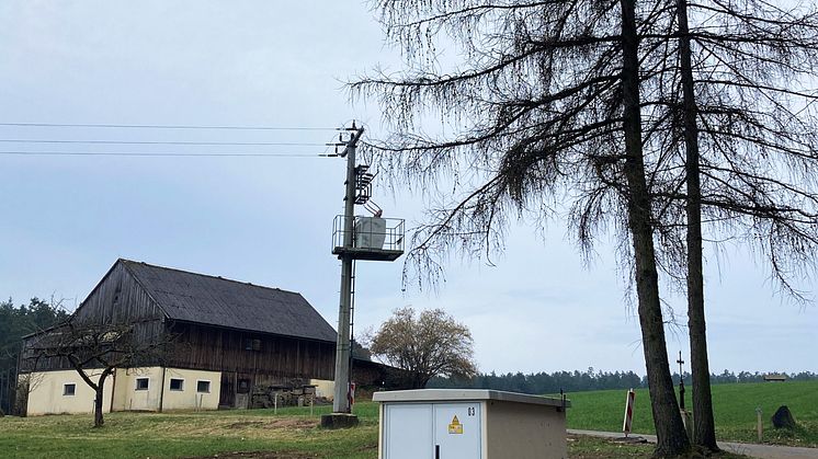 Die digitale Ortsnetzstation (vorne) bei Öd wird künftig die Maststation im Hintergrund ersetzen. Insgesamt vier dieser smarten Netzbestandteile integriert das Bayernwerk anstelle von Mast- und Turmstationen zwischen Kirchendemenreuth und Öd. 