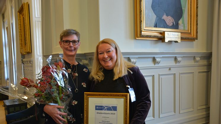 Mikaela Lennvig och verksamhetschefen Maria Bergström tar emot arbetsmiljöpriset 2019.