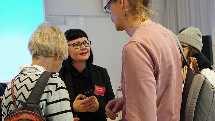 Catharina Fogelström, enhetschef för kultur- och föreningsstöd på Stockholms läns landstings kulturförvaltning på kulturförvaltningens Öppet hus om nya stöden. Foto: K.Wikström. Syntolkning: Catharina samtalar med två personer. 