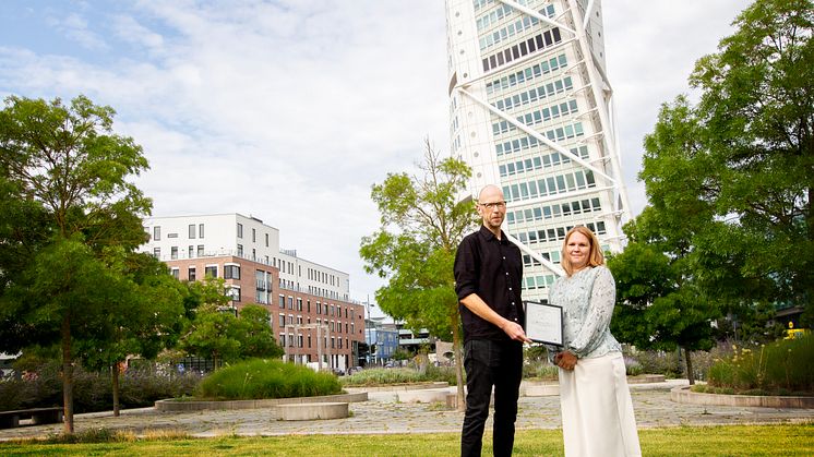 Anders Sjöholm, arbetskonsulent vid Malmö stad, överräcker ett intyg till Maria Nilsson, hållbarhetschef på HSB Malmö.
