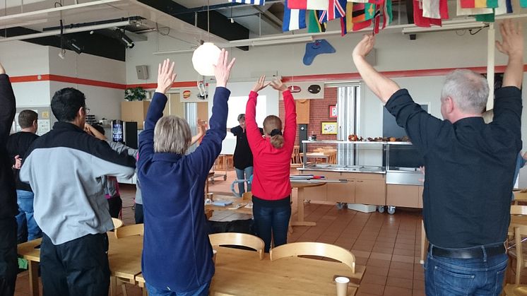 Ergonomen Sara Lindberg låter kursdeltagare göra övningar som sträcker på och mjukar upp kroppen.