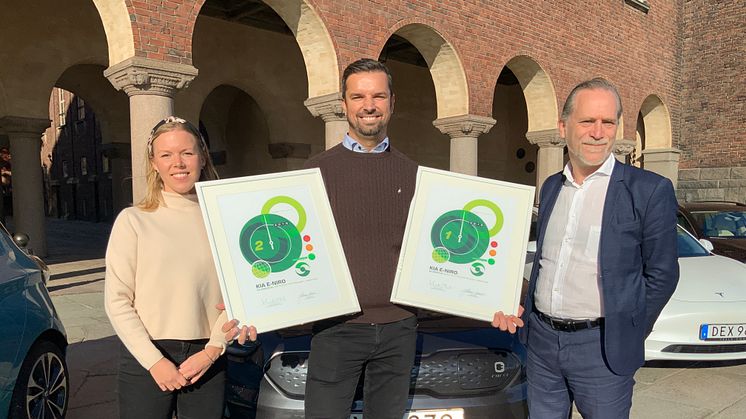 Adnan Hurtic, produktchef hos Kia, visar upp diplomen som Kia e-Niro vunnit. Till vänster Gröna Bilisters ordförande Johanna Grant, till höger Stockholms trafikborgarråd Daniel Helldén.