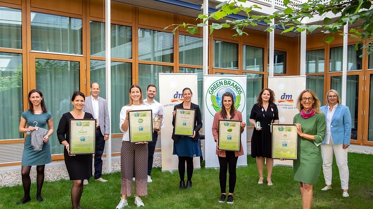 dm-Geschäftsführerin Kerstin Erbe (in Grün) mit den Kolleginnen und Kollegen der dm-Marken-Teams und Norbert Lux (graues Jacket) bei der Übergabe des GREEN BRANDS Gütesiegel.