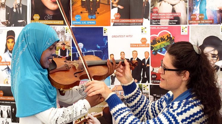 Sångaren och violinisten Åsa Håkansson visar hur man spelar fiol, foto: Marika Yamoun
