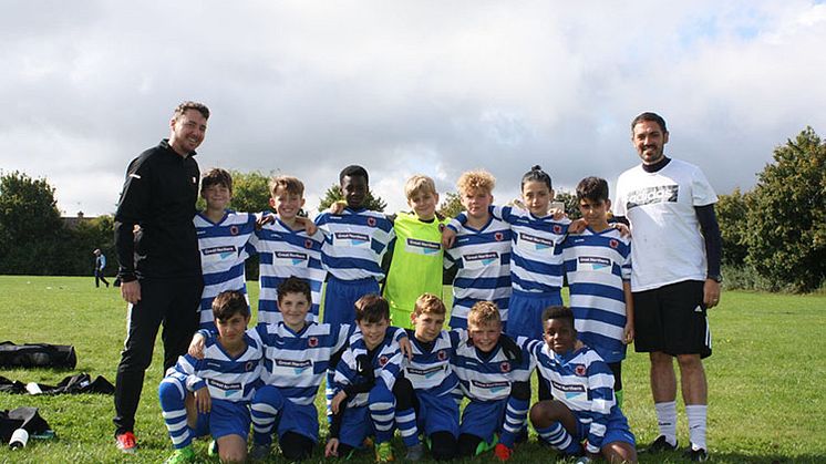 Goal rush with Great Northern: Coach Scott Sellick (left) and manager Shane Davitt (right) with Peterborough Youth Alliance League winners Netherton United Under 11s in their new kit sponsored by rail company Great Northern