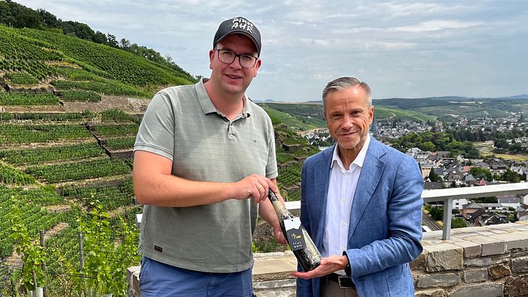 Winzer Peter Kriechel und Zurich Vorstandsmitglied Horst Nussbaumer mit dem ersteigerten Flutwein (Bildrechte: Zurich/Zur medialen Verwendung)