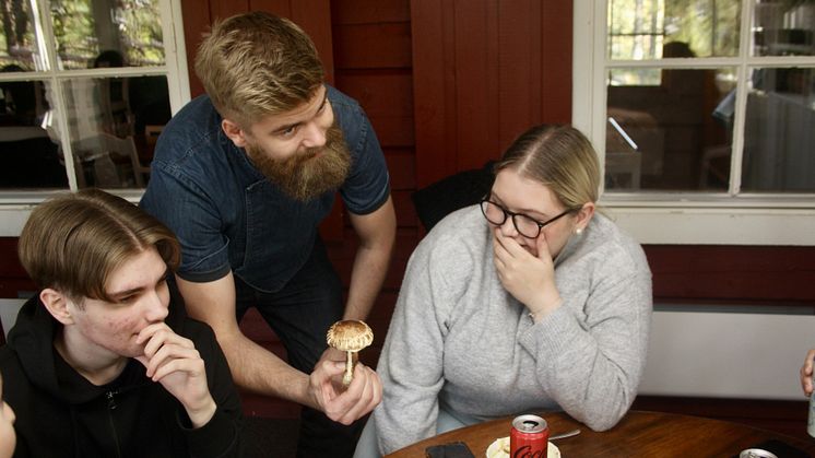 Freddy Holmgren pratar svamp med eleverna Alfred Mannberg och Milla Fransson.