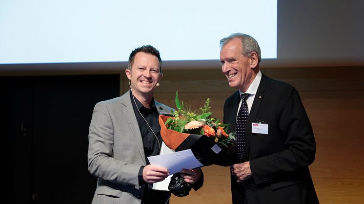 Formand for Torkil Holm priskomitéen Klaus Bock overrækker prisen til lektor Thomas Poulsen fra Aarhus Universitet (foto: Tom Jersø)