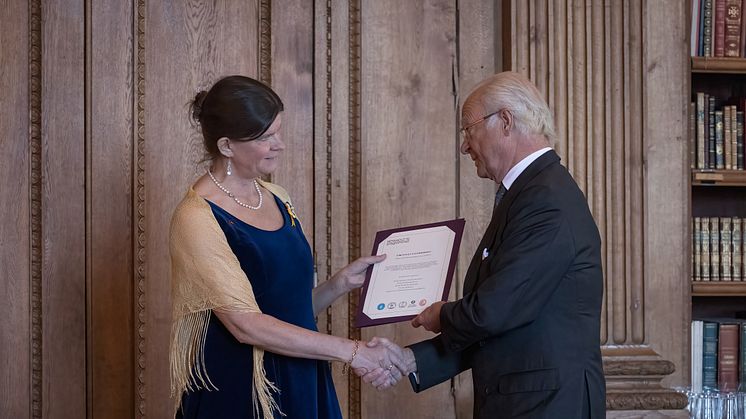 Kungen gratulerar Sofia Hoas, ordförande i Föreningen Svenskbyborna, vid en ceremoni i Bernadottebiblioteket under onsdagen. Föreningen är mottagare av Bernadottepriset 2023. Foto: Björn Strömfeldt/Konstakademien.