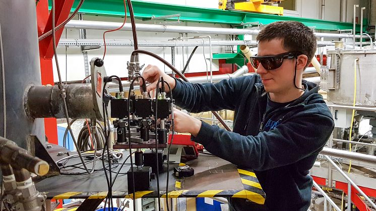 Emil Thorin riktar in lasrarna mot detektorer vid ett experiment i en förgasningsreaktor på RISE AB i Piteå. Foto: Florian Schmidt