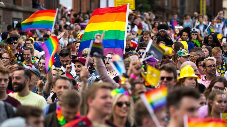 People walking for pride holding up rainbow flags