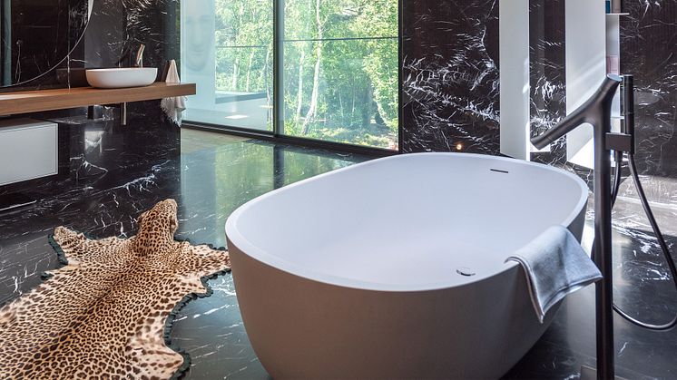 Vid badkaret betonar den eleganta, skulpturella formen på den fristående badkarskranen AXOR Starck Organic den eleganta estetiken.