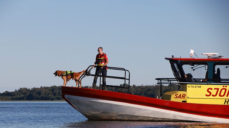 Sjöräddarna Christian Björses och retreivern Bruse i fören på Rescue Hans Carlsson i Västerås.