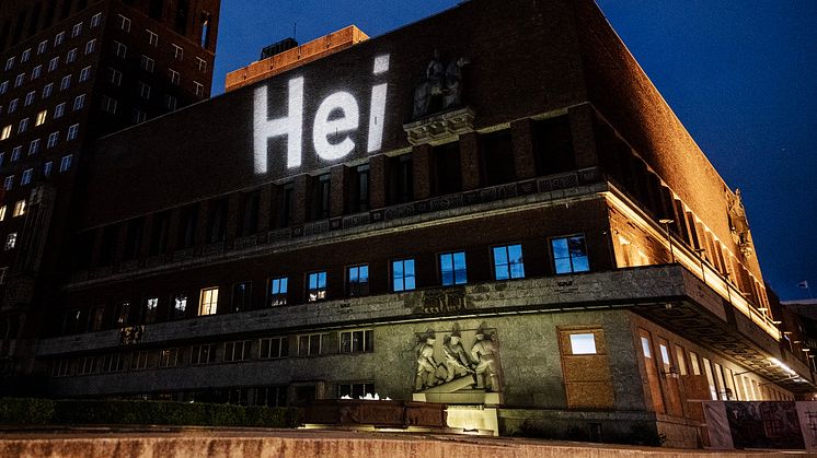 Denne uken har observante Oslofolk lagt merke til et lite ord, med stor betydning, på ulike bygg rundt omkring i byen. Ruter står bak projiseringen og vil de neste ukene fargelegge byen med enda flere hei-budskap.  Foto: Ruter/Jeton Kaçaniku